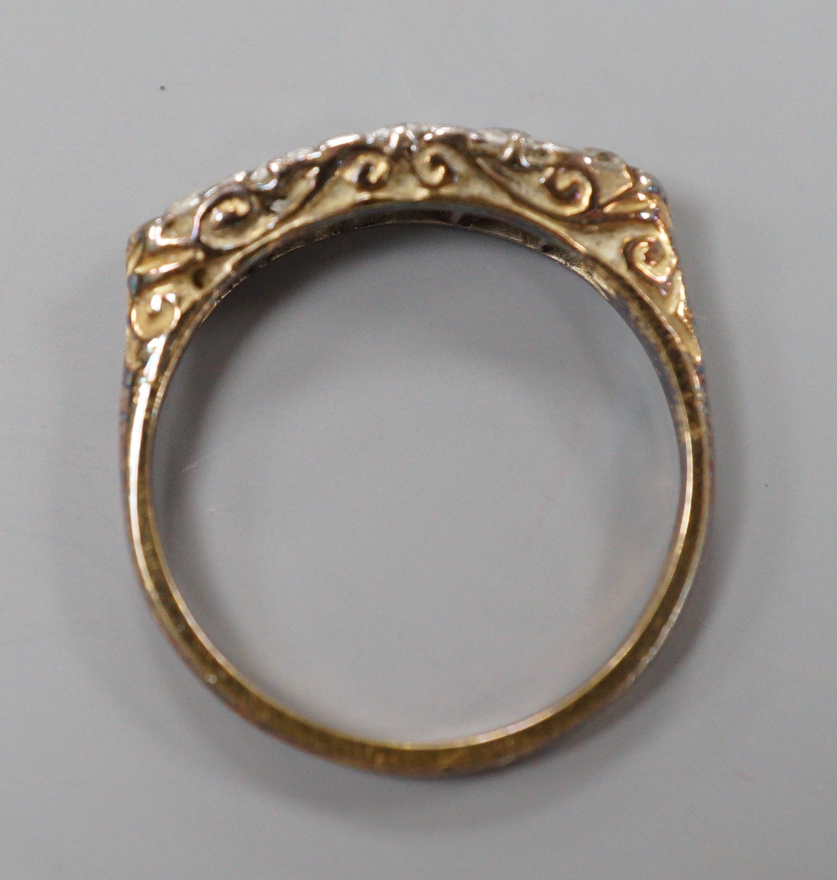 An early 20th century 18ct and graduated five stone diamond set half hoop ring, size P/Q, gross weight 2.7 grams.